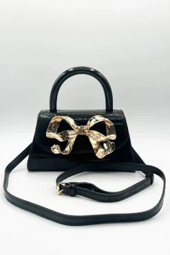 Metallic Bow Top Handle Bag In Black by SVNX