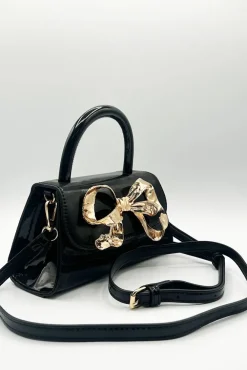 Metallic Bow Top Handle Bag In Black by SVNX