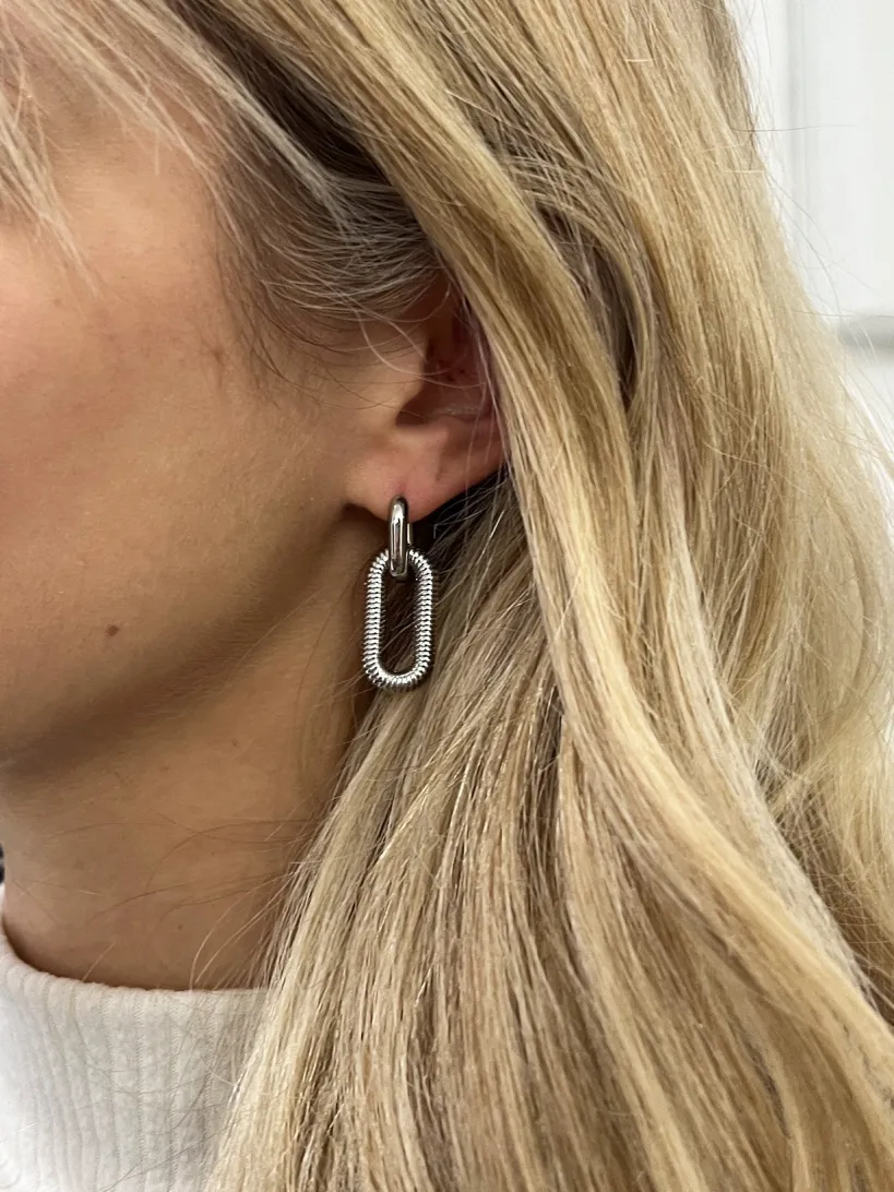 Ribbed Oval Hoop Earrings In Silver by SVNX